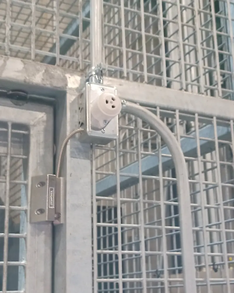 Bosch request-to-exit motion sensor, electric strike lock and armored flex conduit on a high-security pharmaceutical warehouse cage door in Vaughan, ON.