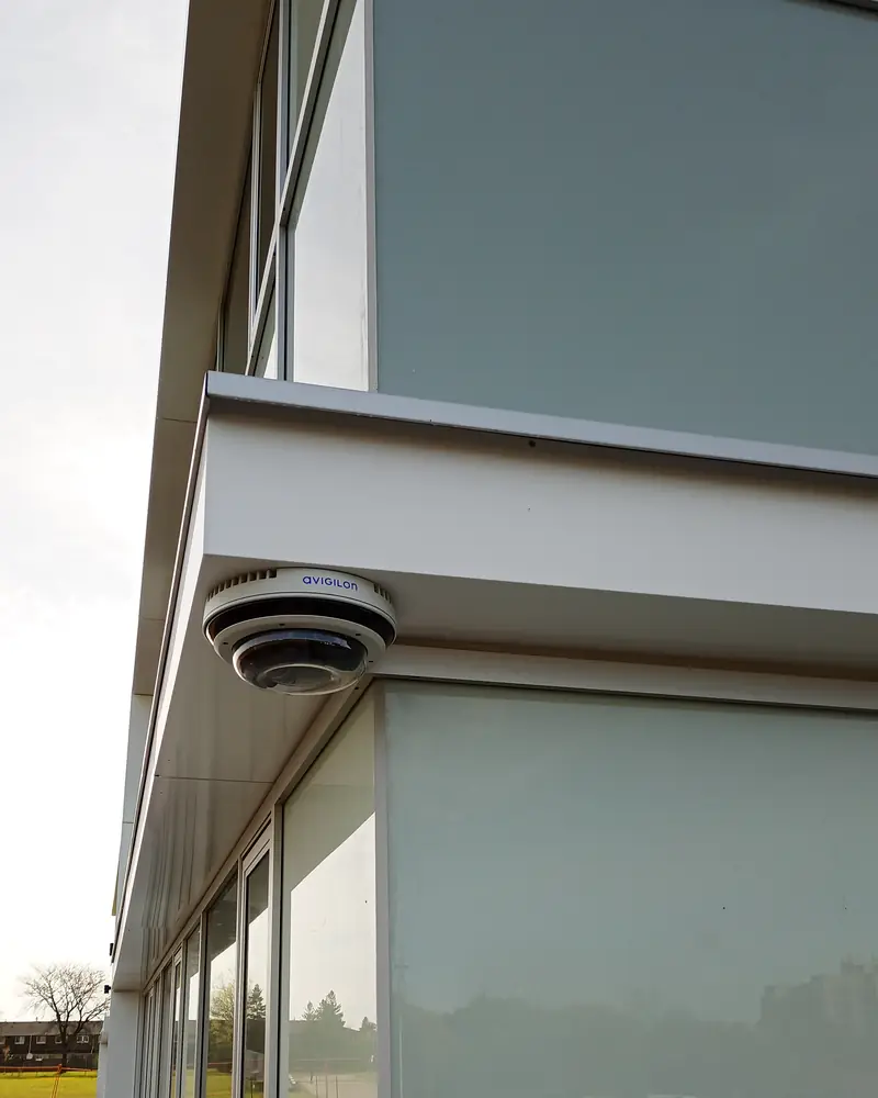 Avigilon 270-degree multi-sensor camera mounted under a glazed automotive dealership canopy in Toronto, ON.