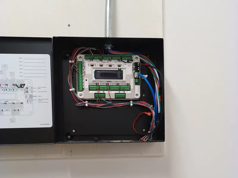 Compact security controller in a wall enclosure fed by surface EMT conduit.