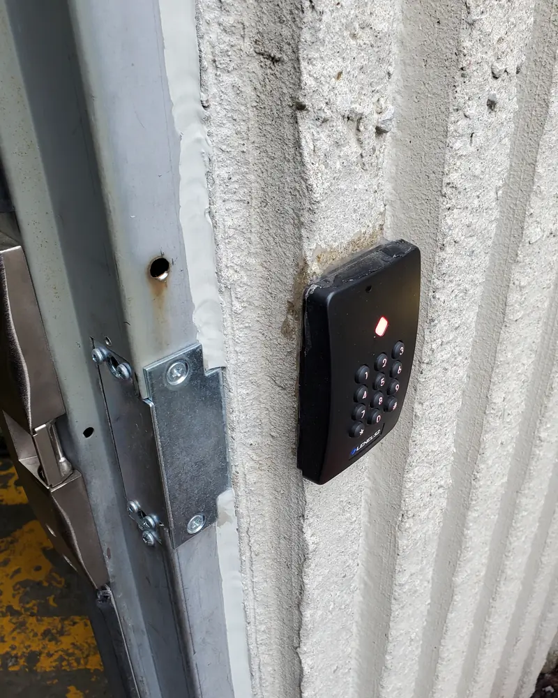 LenelS2 weatherproof PIN and smart-card keypad reader with heavy-duty electric strike at a commercial warehouse doorway in Brampton, ON.