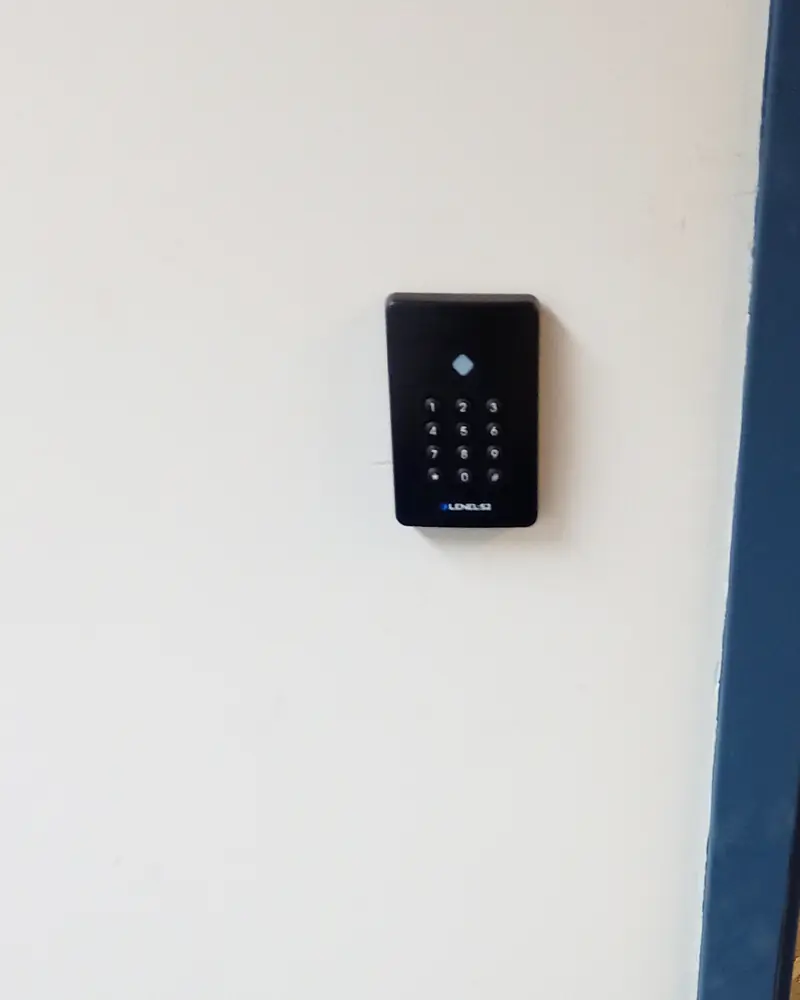 LenelS2 keypad card reader installed on a wall beside a hollow-metal commercial door frame at an industrial facility in Mississauga, ON.